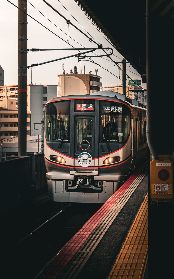 portfolio-03 A sleek train arrives at an urban station in Osaka, Japan during sunset.
