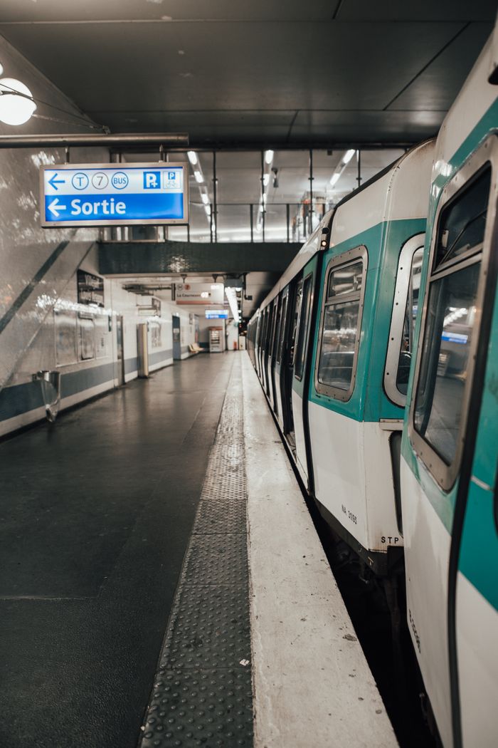 stats-img A Paris Metro train at a clean, empty subway platform with clear signage.